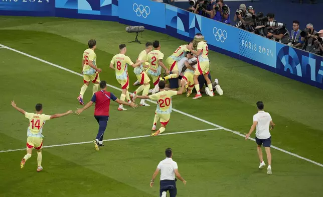 Spain's players celebrate at the end of the men's soccer gold medal match between France and Spain at the Parc des Princes during the 2024 Summer Olympics, Friday, Aug. 9, 2024, in Paris, France. (AP Photo/Vadim Ghirda)