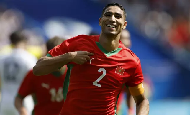 Morocco's Achraf Hakimi celebrates scoring his side's third goal during the quarterfinal men's soccer match between Morocco and the United States at the Parc des Princes during the 2024 Summer Olympics, Friday, Aug. 2, 2024, in Paris, France. (AP Photo/Aurelien Morissard)