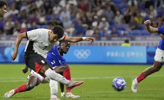 Egypt's Mahmoud Saber shoots to score his side's opening goal during the men's semifinal soccer match between France and Egypt, at Lyon Stadium, during the 2024 Summer Olympics, Monday, Aug. 5, 2024, in Decines, France. (AP Photo/Silvia Izquierdo)