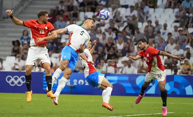 Paraguay's Gilberto Flores (5) is unable to deflect a cross as Egypt's Ibrahim Adel, right, prepares to head the ball in for a goal during a men's quarterfinal soccer match between Egypt and Paraguay at the 2024 Summer Olympics, Friday, Aug. 2, 2024, at Marseille Stadium in Marseille, France. (AP Photo/Julio Cortez)