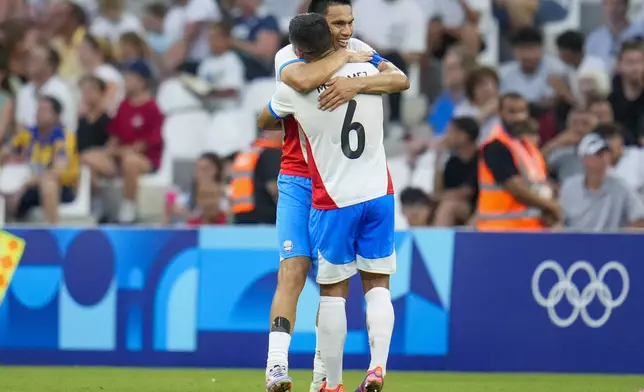 Paraguay's Marcos Gomez (6) gives a hug to Diego Gomez after Gomez scored their side's first goal during a men's quarterfinal soccer match between Egypt and Paraguay at the 2024 Summer Olympics, Friday, Aug. 2, 2024, at Marseille Stadium in Marseille, France. (AP Photo/Julio Cortez)