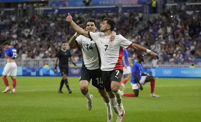 Egypt's Mahmoud Saber, right, celebrates with teammate Zizo after scoring his side's opening goal during the men's semifinal soccer match between France and Egypt, at Lyon Stadium, during the 2024 Summer Olympics, Monday, Aug. 5, 2024, in Decines, France. (AP Photo/Silvia Izquierdo)