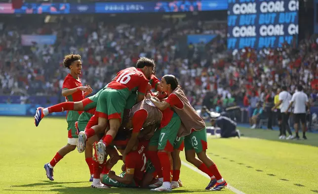 Morocco players celebrate after Ilias Akhomach scored his side's second goal during the quarterfinal men's soccer match between Morocco and the United States at the Parc des Princes during the 2024 Summer Olympics, Friday, Aug. 2, 2024, in Paris, France. (AP Photo/Aurelien Morissard)