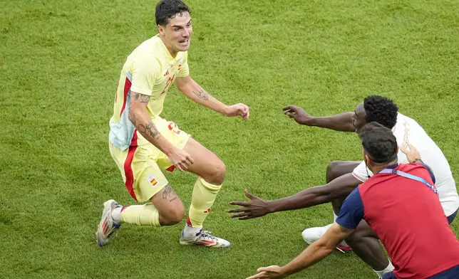 Spain's Sergio Camello, left, celebrates after scoring his side's fourth goal during the men's soccer gold medal match between France and Spain at the Parc des Princes during the 2024 Summer Olympics, Friday, Aug. 9, 2024, in Paris, France. (AP Photo/Vadim Ghirda)