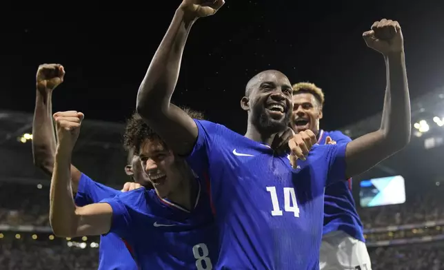 France's Jean-Philippe Mateta (14) celebrates with teammates after scoring his side's 2nd goal in extra time during the men's semifinal soccer match between France and Egypt, at Lyon Stadium, during the 2024 Summer Olympics, Monday, Aug. 5, 2024, in Decines, France. (AP Photo/Silvia Izquierdo)