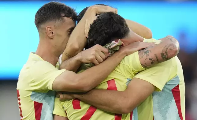 Spain's Sergio Camello, back to camera, celebrates with teammates after scoring his team's fifth goal during the men's soccer gold medal match between France and Spain at the Parc des Princes during the 2024 Summer Olympics, Friday, Aug. 9, 2024, in Paris, France. (AP Photo/Francisco Seco)