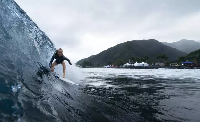 Kelia Gallina, 11, surfs her home shore break during a break in the 2024 Summer Olympics surfing competition, Wednesday, July 31, 2024, in Teahupo'o, Tahiti. While Teahupo'o has been a coveted destination for surfers from around the world for decades, it's only in more recent years that local surf culture and talent has begun to develop across Tahiti. (AP Photo/Gregory Bull)