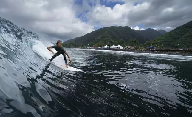 Liam Sham Koua, 11, surfs his home shore break during a break in the 2024 Summer Olympics surfing competition, Wednesday, July 31, 2024, in Teahupo'o, Tahiti. While Teahupo'o has been a coveted destination for surfers from around the world for decades, it's only in more recent years that local surf culture and talent has begun to develop across Tahiti. (AP Photo/Gregory Bull)