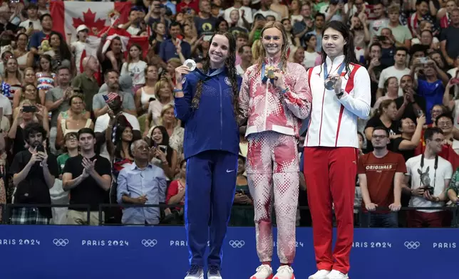 Summer McIntosh, center, of Canada, stands on the podium with silver medal winner Regan Smith, left, of the United States, and bronze medal winner Yufei Zhang, of China, following the women's 200-meter butterfly final at the 2024 Summer Olympics, Thursday, Aug. 1, 2024, in Nanterre, France. (AP Photo/Matthias Schrader)