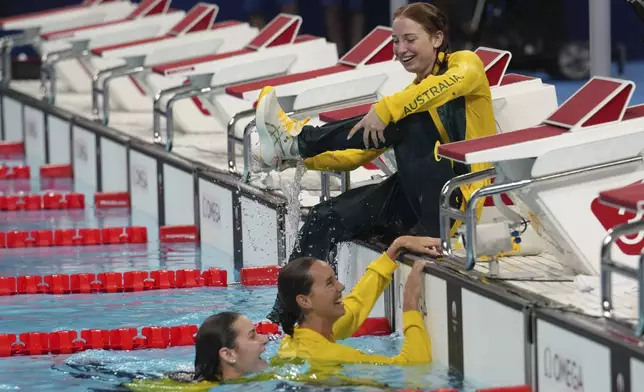 Australia's Mollie O'Callaghan pours water from her shoe after she and her teammates plunged into the pool after they were awarded silver medals for the women's 4x100-meter medley relay at the Summer Olympics in Nanterre, France, Sunday, Aug. 4, 2024. (AP Photo/Tsvangirayi Mukwazhi)