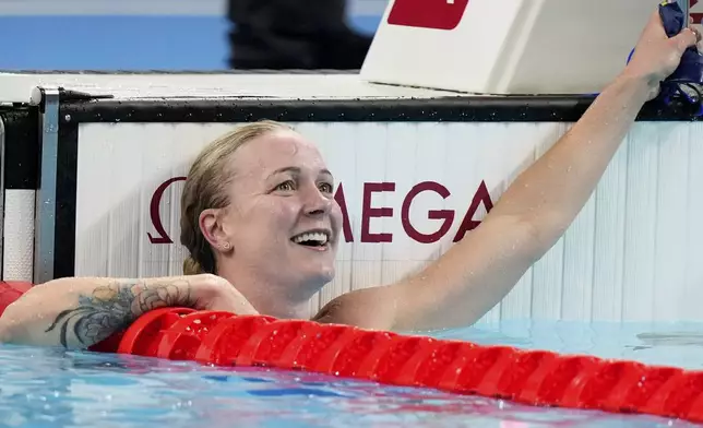 Sweden's Sarah Sjoestroem looks at the board after winning the gold medal in the women's 50-meter freestyle final at the Summer Olympics in Nanterre, France, Sunday, Aug. 4, 2024. (AP Photo/Brynn Anderson)