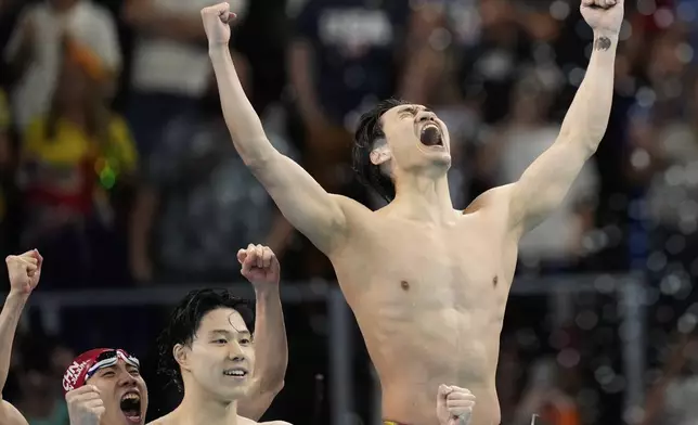 China's swim relay team members celebrate winning the gold medal in the men's 4x100-meter medley relay final at the Summer Olympics in Nanterre, France, Sunday, Aug. 4, 2024. (AP Photo/Brynn Anderson)