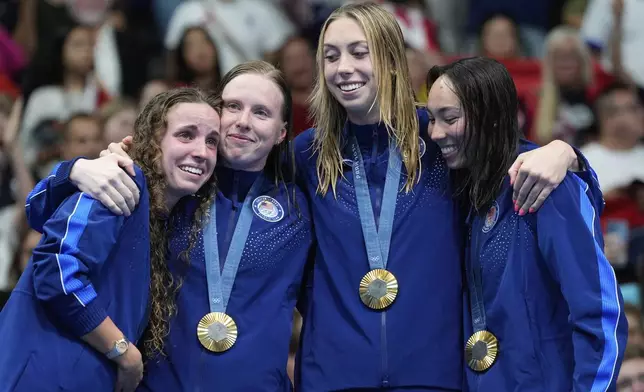 United States' gold medalists Regan Smith, Lilly King, Gretchen Walsh, and Torri Huske pose for photo on the podium for the women's 4x100-meter medley relay at the Summer Olympics in Nanterre, France, Sunday, Aug. 4, 2024. (AP Photo/Natacha Pisarenko)