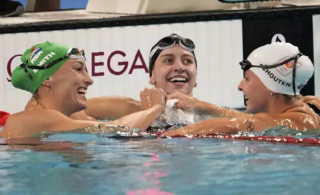 Tatjana Smith, of South Africa, from left, Kate Douglass, of the United States, and Tes Schouten, of the Netherlands, celebrate after the women's 200-meter breaststroke final at the 2024 Summer Olympics in Nanterre, France, Thursday, Aug. 1, 2024. (AP Photo/Ashley Landis)