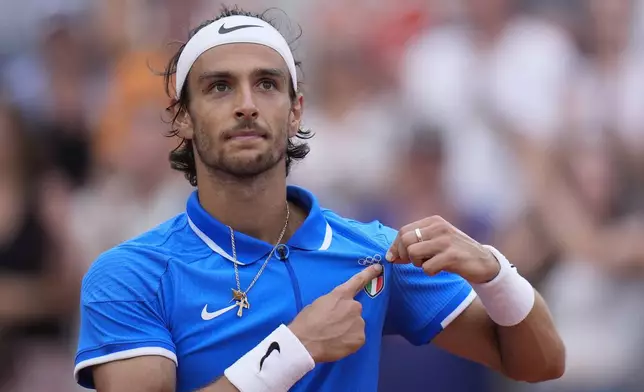 Lorenzo Musetti of Italy celebrates after defeating Alexander Zverev of Germany in their men's singles quarterfinals match, at the 2024 Summer Olympics, Thursday, Aug.1, 2024, at the Roland Garros stadium in Paris, France. (AP Photo/Andy Wong)