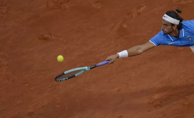 Lorenzo Musetti of Italy returns a shot to Felix Auger-Aliassime of Canada during their men's singles bronze medal match, at the 2024 Summer Olympics, Saturday, Aug. 3, 2024, at the Roland Garros stadium in Paris, France. (AP Photo/Andy Wong)