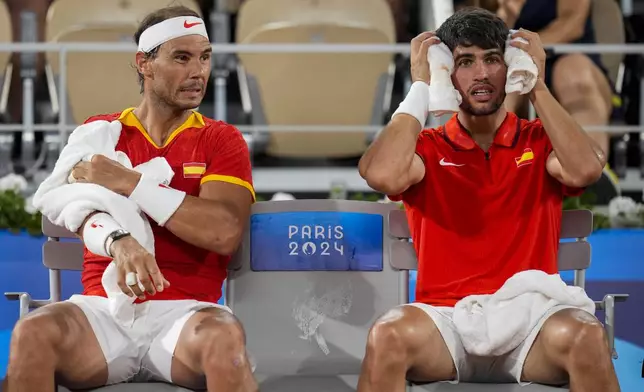 Rafael Nadal, left, and Carlos Alcaraz of Spain react during their match against Austin Krajicek and Rajeev Ram of the USA during the men's doubles quarter-final tennis competition at the Roland Garros stadium, at the 2024 Summer Olympics, Wednesday, July 31, 2024, in Paris, France. (AP Photo/Manu Fernandez)