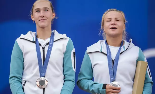 Andreeva and Diana Shnaider of Individual Neutral Athlete show their silver medals after losing to Sara Errani and Jasmine Paolini of Italy after women's doubles gold medal tennis match at the Roland Garros stadium, at the 2024 Summer Olympics, Sunday, Aug. 4, 2024, in Paris, France. (AP Photo/Manu Fernandez)