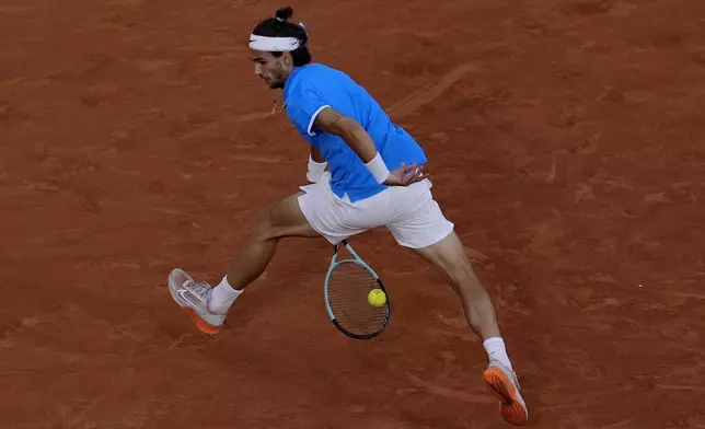 Lorenzo Musetti of Italy returns a shot to Felix Auger-Aliassime of Canada during their men's singles bronze medal match, at the 2024 Summer Olympics, Saturday, Aug. 3, 2024, at the Roland Garros stadium in Paris, France. (AP Photo/Andy Wong)