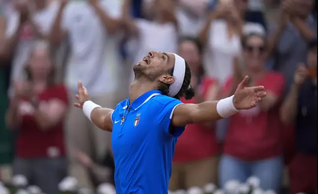 Lorenzo Musetti of Italy celebrates after defeating Alexander Zverev of Germany in their men's singles quarterfinals match, at the 2024 Summer Olympics, Thursday, Aug.1, 2024, at the Roland Garros stadium in Paris, France. (AP Photo/Andy Wong)