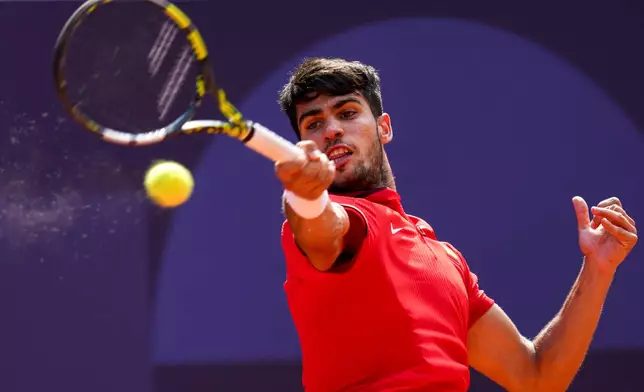 Carlos Alcaraz of Spain returns the ball against Tommy Paul, of United States during their men's quarter-final match at the Roland Garros stadium, at the 2024 Summer Olympics, Thursday, Aug. 1, 2024, in Paris, France. (AP Photo/Manu Fernandez)