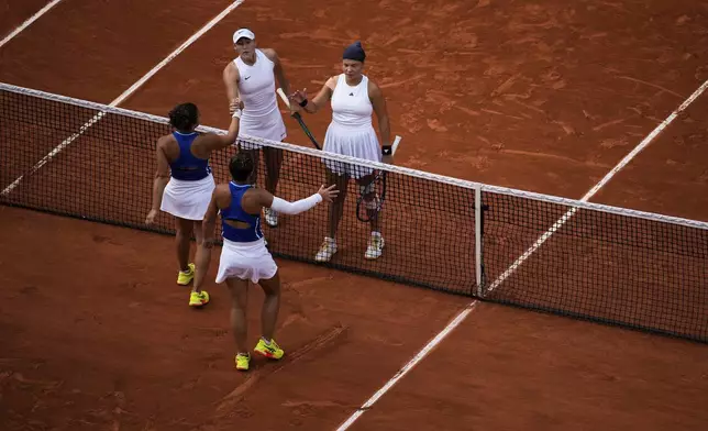 Sara Errani and Jasmine Paolini of Italy shake hands with Mirra Andreeva and Diana Shnaider of Individual Neutral Athlete after the women's doubles gold medal tennis match at the Roland Garros stadium, at the 2024 Summer Olympics, Sunday, Aug. 4, 2024, in Paris, France. (AP Photo/Louise Delmotte)