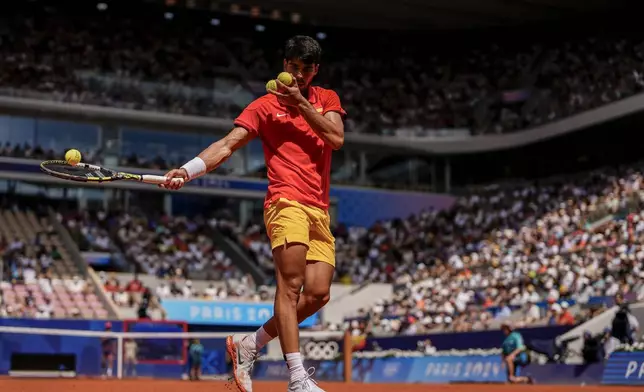 Carlos Alcaraz of Spain preparest o serve against Tommy Paul, of United States during their men's quarter-final match at the Roland Garros stadium, at the 2024 Summer Olympics, Thursday, Aug. 1, 2024, in Paris, France. (AP Photo/Manu Fernandez)