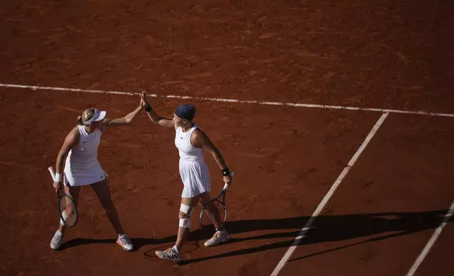 Mirra Andreeva and Diana Shnaider of Individual Neutral Athlete react as they play against Sara Errani and Jasmine Paolini of Italy during women's doubles gold medal tennis match at the Roland Garros stadium, at the 2024 Summer Olympics, Sunday, Aug. 4, 2024, in Paris, France. (AP Photo/Louise Delmotte)