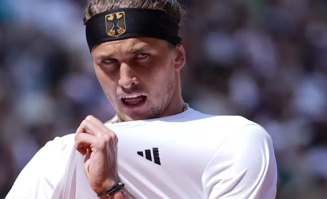 Alexander Zverev of Germany pulls his shirt after losing a point to Lorenzo Musetti of Italy during their men's singles quarterfinals match, at the 2024 Summer Olympics, Thursday, Aug.1, 2024, at the Roland Garros stadium in Paris, France. (AP Photo/Andy Wong)