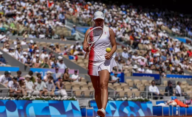 Iga Swiatek of Poland prepares to serve against Qinwen Zheng of China during their women's semifinals match at the Roland Garros stadium, at the 2024 Summer Olympics, Thursday, Aug. 1, 2024, in Paris, France. (AP Photo/Manu Fernandez)