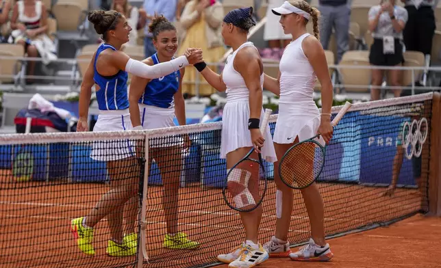 Sara Errani and Jasmine Paolini of Italy shake hands after winning over Mirra Andreeva and Diana Shnaider of Individual Neutral Athlete during women's doubles gold medal tennis match at the Roland Garros stadium, at the 2024 Summer Olympics, Sunday, Aug. 4, 2024, in Paris, France. (AP Photo/Manu Fernandez)