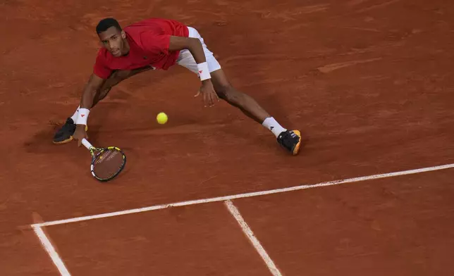 Felix Auger-Aliassime of Canada returns a forehand shot to Lorenzo Musetti of Italy during their men's singles bronze medal match, at the 2024 Summer Olympics, Saturday, Aug. 3, 2024, at the Roland Garros stadium in Paris, France. (AP Photo/Andy Wong)