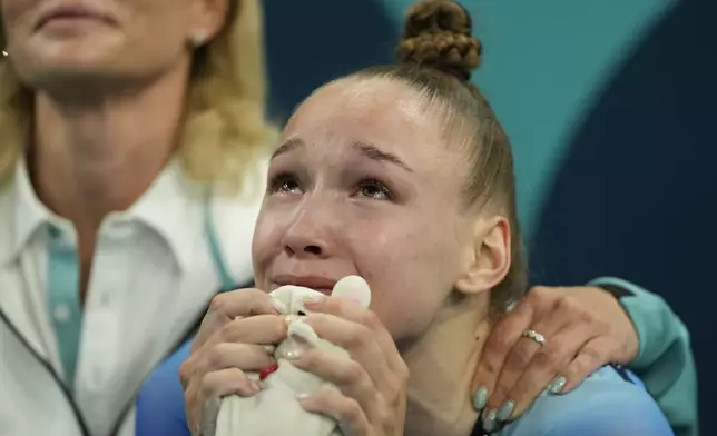 Anzhela Bladtceva of the Individual Neutral Athletes waits for scores after competing during the women's trampoline finals in Bercy Arena at the 2024 Summer Olympics, Friday, Aug. 2, 2024, in Paris, France. (AP Photo/Charlie Riedel)