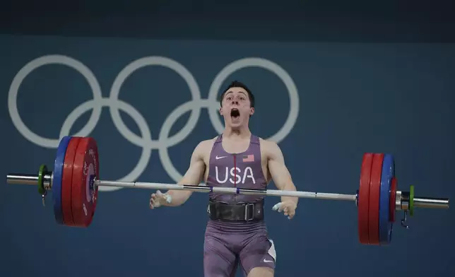 Hampton Morris of the United States reacts as he competes during the men's 61kg weightlifting event at the 2024 Summer Olympics, Wednesday, Aug. 7, 2024, in Paris, France. (AP Photo/Kin Cheung)