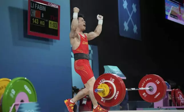 Li Fabin of China reacts as he competes during the men's 61kg weightlifting event at the 2024 Summer Olympics, Wednesday, Aug. 7, 2024, in Paris, France. (AP Photo/Kin Cheung)