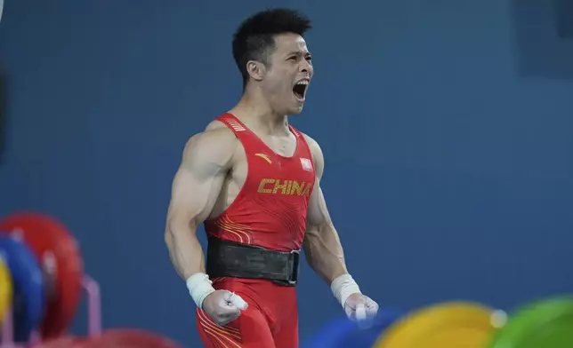 Li Fabin of China reacts as he competes during the men's 61kg weightlifting event at the 2024 Summer Olympics, Wednesday, Aug. 7, 2024, in Paris, France. (AP Photo/Kin Cheung)