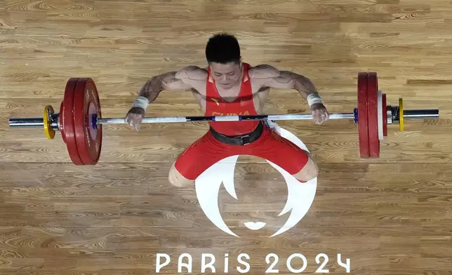 Li Fabin of China competes during the men's 61kg weightlifting event at the 2024 Summer Olympics, Wednesday, Aug. 7, 2024, in Paris, France. (AP Photo/Dita Alangkara,Pool)