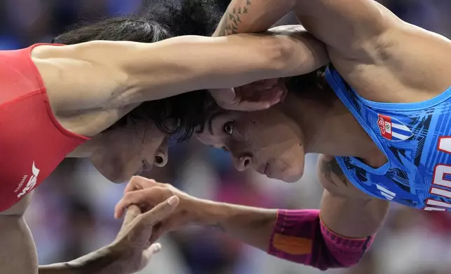 India's Vinesh Vinesh and Cuba's Yusneylys Guzman, right, compete during their women's freestyle 50kg wrestling semifinal match, at Champ-de-Mars Arena, during the 2024 Summer Olympics, Tuesday, Aug. 6, 2024, in Paris, France. (AP Photo/Eugene Hoshiko)