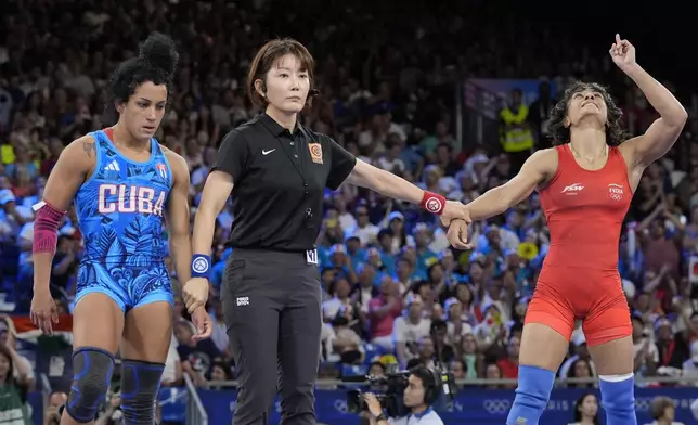 India's Vinesh Vinesh, right, celebrates after defeating Cuba's Yusneylys Guzman compete during their women's freestyle 50kg wrestling semifinal match, at Champ-de-Mars Arena, during the 2024 Summer Olympics, Tuesday, Aug. 6, 2024, in Paris, France. (AP Photo/Eugene Hoshiko)