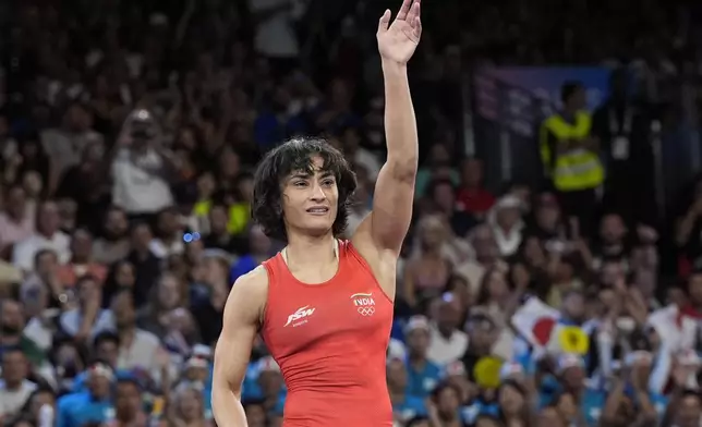 India's Vinesh Vinesh celebrates after defeating Cuba's Yusneylys Guzman during their women's freestyle 50kg wrestling semifinal match, at Champ-de-Mars Arena, during the 2024 Summer Olympics, Tuesday, Aug. 6, 2024, in Paris, France. (AP Photo/Eugene Hoshiko)