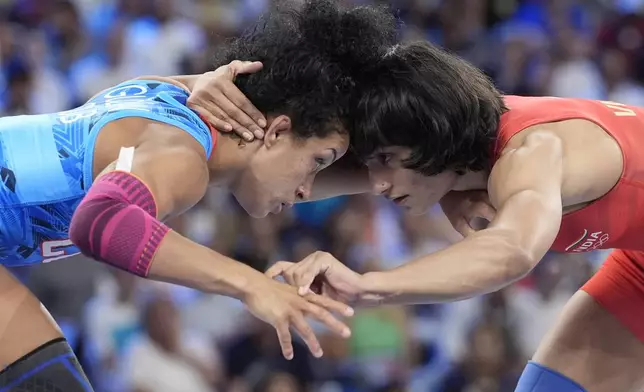 India's Vinesh Vinesh and Cuba's Yusneylys Guzman, left, compete during their women's freestyle 50kg wrestling semifinal match, at Champ-de-Mars Arena, during the 2024 Summer Olympics, Tuesday, Aug. 6, 2024, in Paris, France. (AP Photo/Eugene Hoshiko)