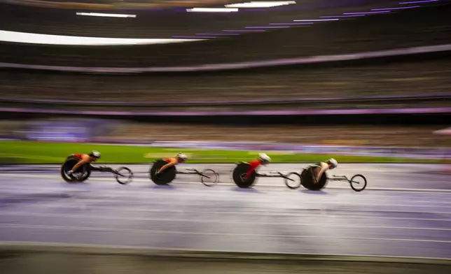 Paralympic athletes compete at Women's 5000m - T54 round 1, at the Stade de France stadium, during the 2024 Paralympics, Friday, Aug. 30, 2024, in Paris, France. (AP Photo/Emilio Morenatti)