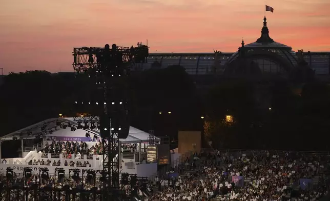 The crowd attends the Opening Ceremony for the 2024 Paralympics, Wednesday, Aug. 28, 2024, on the Concorde plaza, with the Grand Palais in background, in Paris, France. (AP Photo/Thomas Padilla)