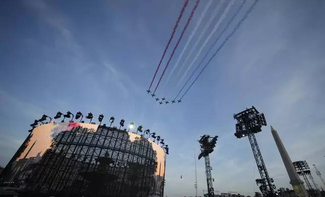 Alpha jets form the Patrouille de France fly over the Concorde plaza during the Opening Ceremony for the 2024 Paralympics, Wednesday, Aug. 28, 2024, in Paris, France. (AP Photo/Christophe Ena)