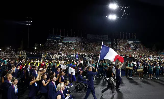 Flagbearers Alexis Hanquinquant of France and Nantenin Keita of France lead their delegation during the Opening Ceremony for the 2024 Paralympics, Wednesday, Aug. 28, 2024, in Paris, France. (Gonzalo Fuentes/Pool Photo via AP)