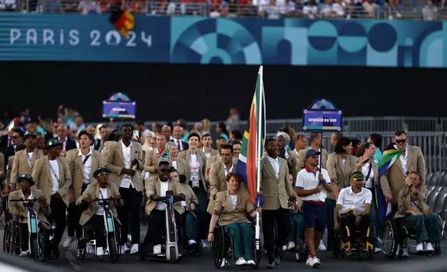 Flagbearers Mpumelelo Mhlongo of South Africa and Kat Swanepoel of South Africa lead their contingent during the Opening Ceremony for the 2024 Paralympics, Wednesday, Aug. 28, 2024, in Paris, France. (Gonzalo Fuentes/Pool Photo via AP)