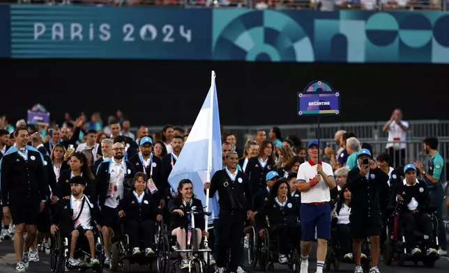 Flagbearers Hernan Barreto of Argentina and Coty Garrone of Argentina lead their contingent during the Opening Ceremony for the 2024 Paralympics, Wednesday, Aug. 28, 2024, in Paris, France. (Gonzalo Fuentes/Pool Photo via AP)