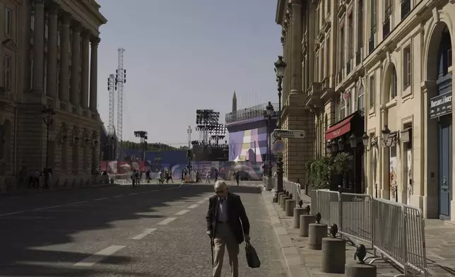 FILE - A man walks next to the Place de la Concorde, Thursday, Aug. 22, 2024 in Paris. With the Olympics behind it, Paris is getting ready for the next big sporting event on the calendar this summer: the Paralympics. (AP Photo/Thibault Camus, File)