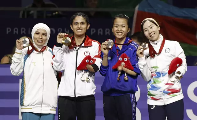 From left: Silver medalist Ziyodakhon Isakova from Uzbekistan, gold medalist Leonor Angelica Espinoza Carranza from Peru, co-bronze medalist Khwansuda Phuangkitcha of Thailand, and co-bronze medalist Zakia Khudadadi, from Afghanistan and part of the Paralympic Refugee team, celebrate after the Para Taekwondo K44-47kg class competition, during the Paralympic Games in Paris, Thursday, Aug. 29, 2024. (AP Photo/Madeleine Mertens)