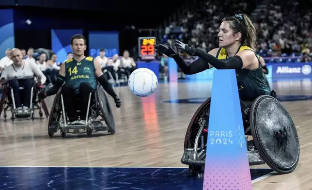 Ella Sabljak of Australia takes the ball to try during the 2024 Paralympics Wheelchair Rugby match Australia against Great Britain at the Champs Mars Arena Thursday, Aug. 29, 2024, in Paris, France. (AP Photo/Michel Euler)